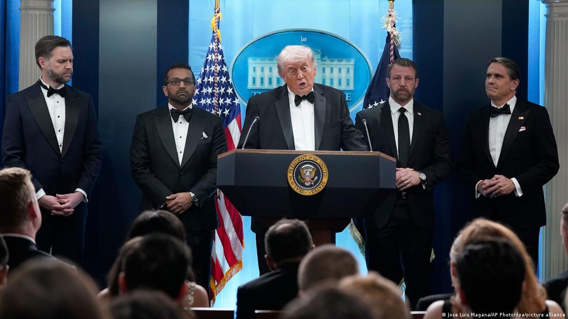 Donald Trump fala a jornalistas ao lado de membros do seu governo