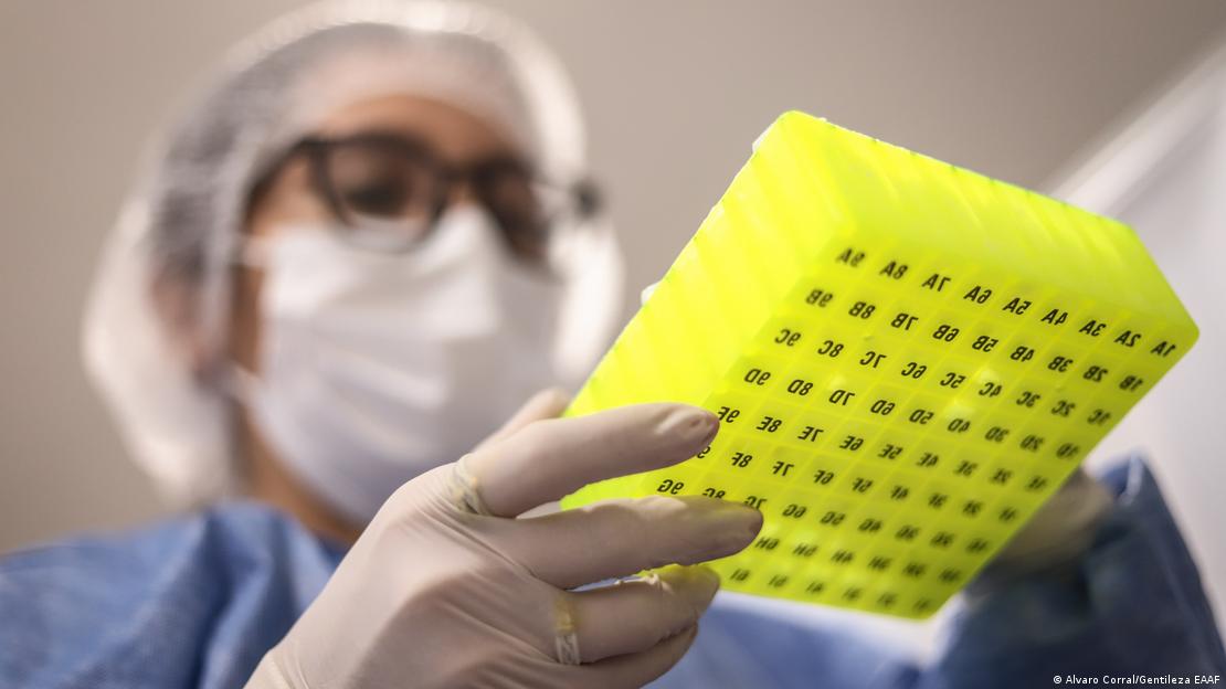Una persona con mascarilla revisa material de laboratorio.