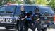 Two armed police officers stand by a black police van in Washington Two armed police officers stand by a black police van in Washington