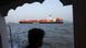 An Indian man looks at a container ship of the coast of Mumbai (May 2026) An Indian man looks at a container ship of the coast of Mumbai (May 2026)