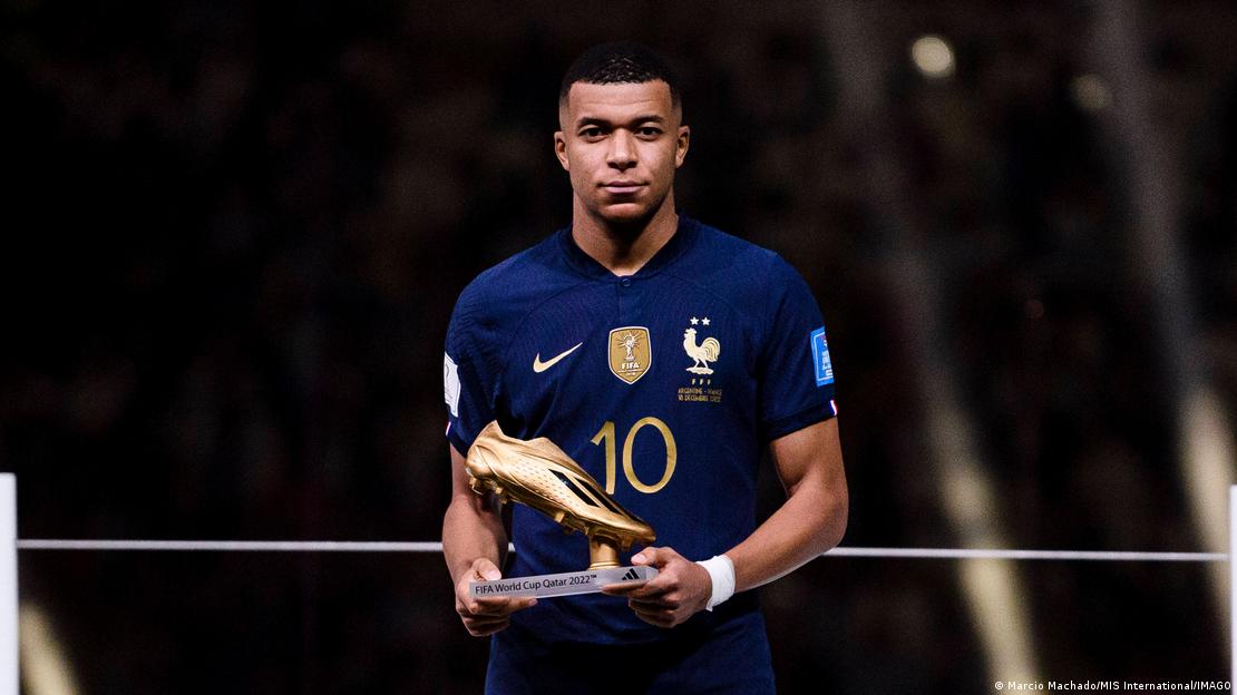 Kylian Mbappe, 2022 Dünya Kupası'nda kazandığı "Altın Ayakkabı" ödülünü elinde tutarak poz veriyor.