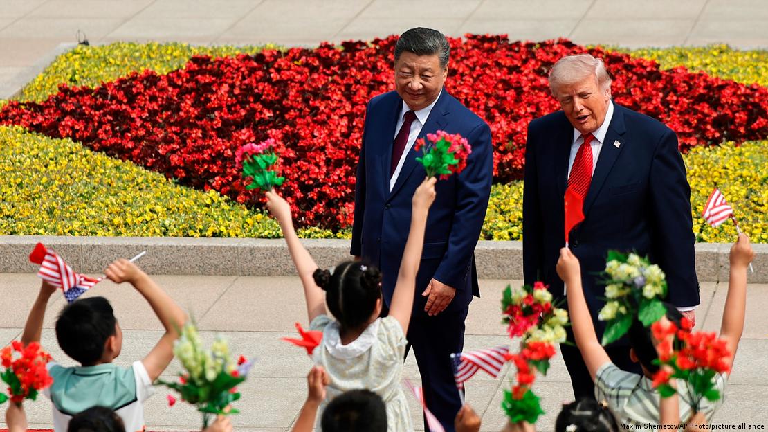 Şi Cinping ve Donald Trump kendilerini ellerindeki Çin ve ABD bayraklarıyla karşılayan çocuklara doğru yaklaşıyor.