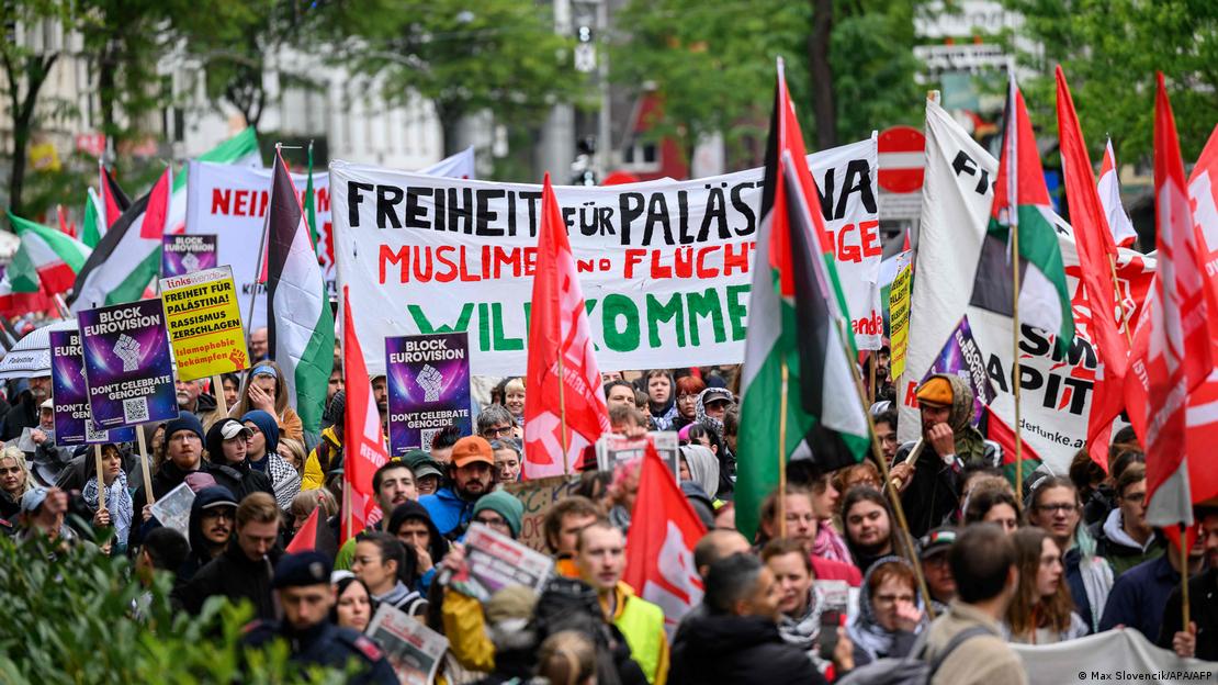 Viyana'daki bir protestoda kalabalık Filistin bayrakları ve Eurovision'un boykot edilmesi çağrısı yapan pankartlar taşıyor. Viyana'daki bir protestoda kalabalık Filistin bayrakları ve Eurovision'un boykot edilmesi çağrısı yapan pankartlar taşıyor.