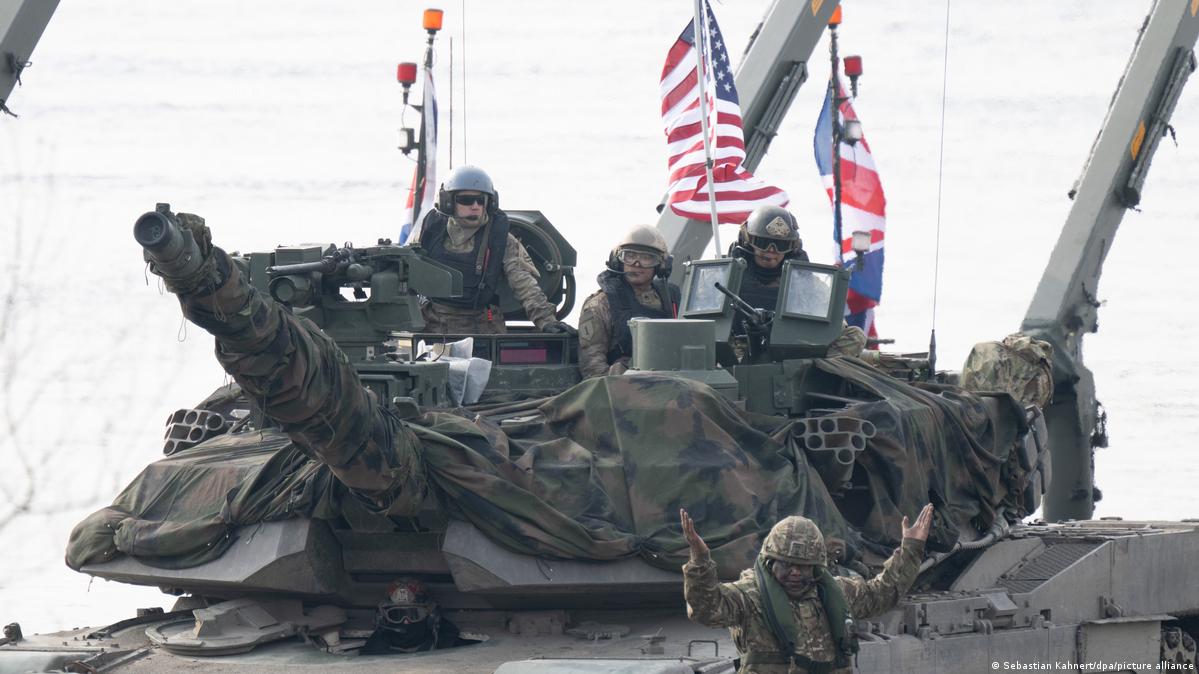 Soldiers in a tank with an US and UK flag