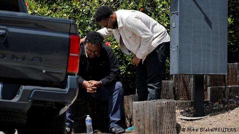 En la imagen un hombre llora y es consolado por otra persona tras el ataque.