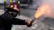 Homem mascarado segura fogo de artifício em manifestação antigoverno na Bolívia Homem mascarado segura fogo de artifício em manifestação antigoverno na Bolívia