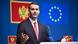 A man (Milojko Spajic) gesticulates as he speaks at a press conference. Behind him are the flags of Montenegro and the EU. Brussels, Belgium, December 16, 2025 A man (Milojko Spajic) gesticulates as he speaks at a press conference. Behind him are the flags of Montenegro and the EU. Brussels, Belgium, December 16, 2025
