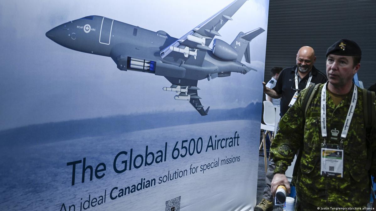 Attendees pass an image of the Bombardier Global 6500 Aircraft at the CANSEC trade show in Ottawa on Wednesday, May 31, 2023