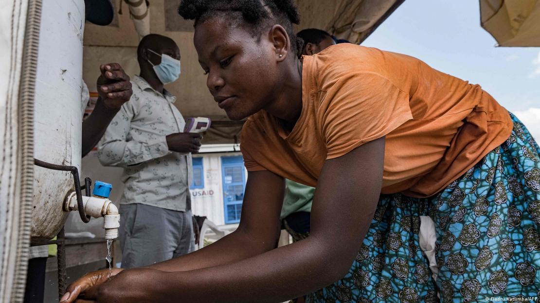 Una mujer se lava las manos en la frontera entre Uganda y la República Democrática del Congo.