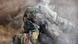 A soldier seen with smoke wearing a gasmask A soldier seen with smoke wearing a gasmask