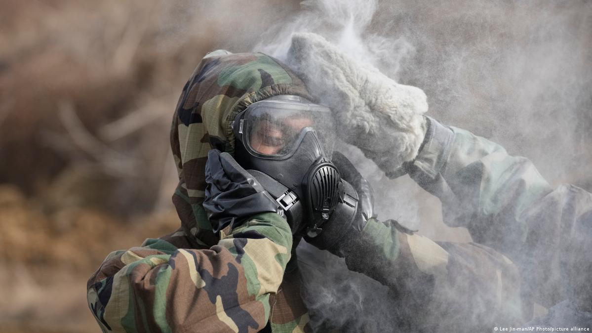 A soldier seen with smoke wearing a gasmask