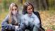 Teenage girls in casual clothes vape electronic cigarettes in a park. Teenage girls in casual clothes vape electronic cigarettes in a park.