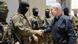 Netanyahu aperta a mão de um soldado, enquanto outros esperam o cumprimento