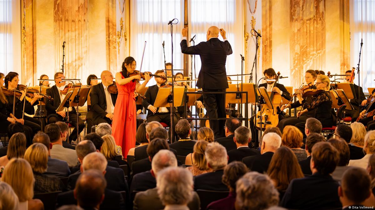 An orchestra performing with the audience sitting right in front of the musicians.