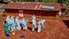 Red Cross workers wearing protective gear disinfect a patch of earth next to a hut with a corrugated iron roof Red Cross workers wearing protective gear disinfect a patch of earth next to a hut with a corrugated iron roof