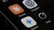 An iPhone screen photographed at close range displays four AI assistant application icons Claude, ChatGPT, Gemini and Grok by xAI An iPhone screen photographed at close range displays four AI assistant application icons Claude, ChatGPT, Gemini and Grok by xAI