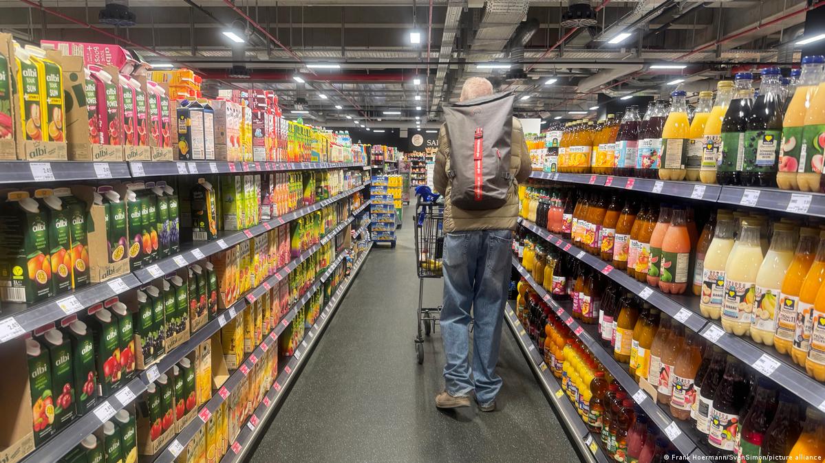 A person walking down the aisle of a supermarket.