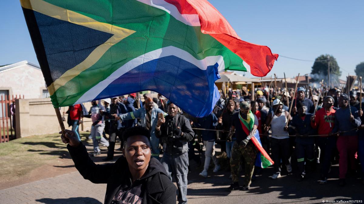A demonstrator waves South Africa's flag during a protest calling for the deportation of undocumented immigrants on June 5, 2026