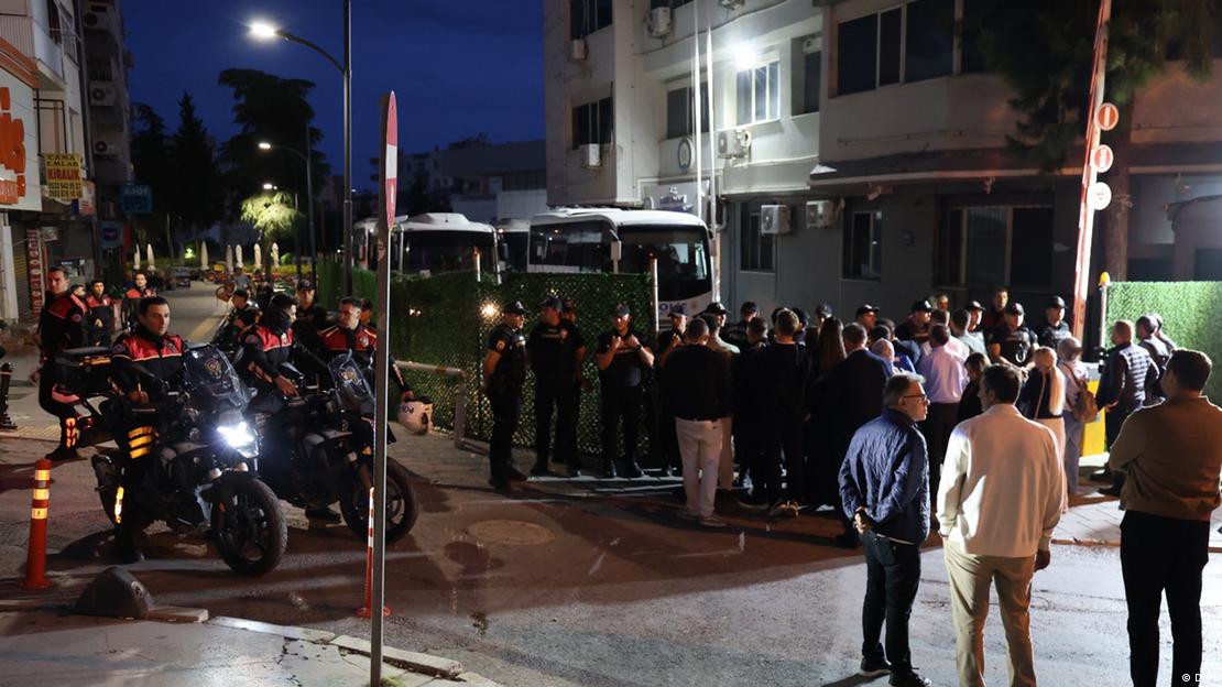 Buca'da polis araçlarının önündeki emniyet görevlileri ve kalabalık
