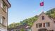 A house with a Swiss flag against a blue sky A house with a Swiss flag against a blue sky