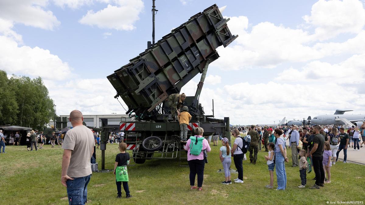 Visitors in front of a Patriot missile system at a military show