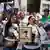 Mujeres con retratos en protesta en la calle. Una de ellas habla por un altavoz.