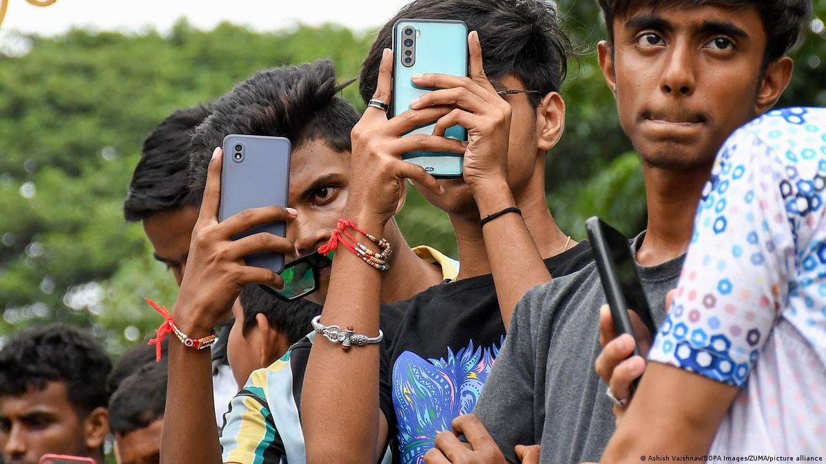 A group of young boys hold up cellphones to take pictures (file photo)