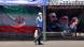 Un hombre camina frente a un cartel propagandístico iraní. Un hombre camina frente a un cartel propagandístico iraní.