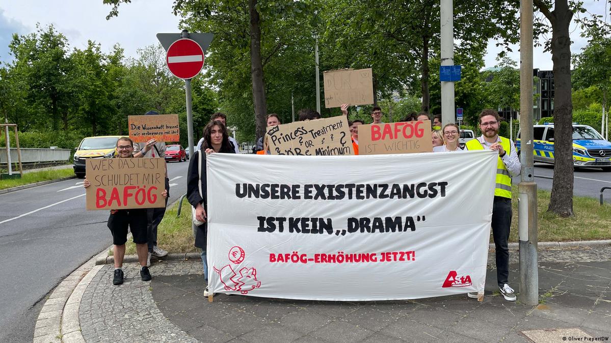 Students protesting for university funding reforms in Germany behind a sign that reads: