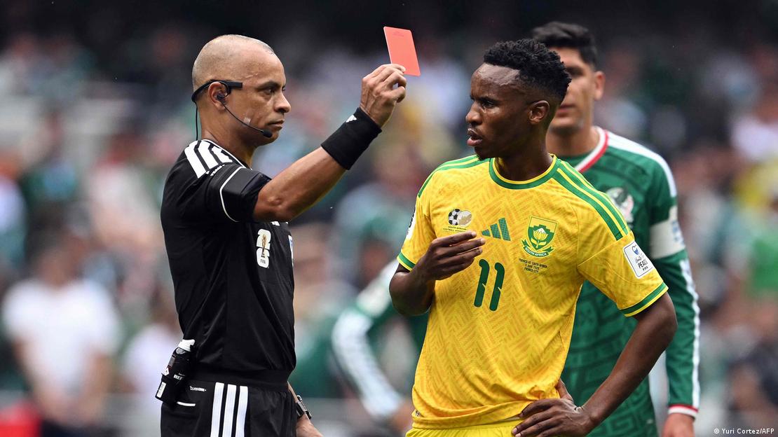 El juez brasileño Wilton Sampaio muestra la tarjeta roja a Themba Zwane por una falta.