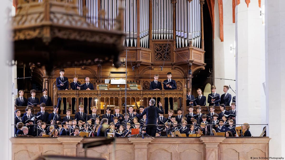 The St. Thomas Boys Choir performing in the St. Thomas church, with the pipes of an organ above them.