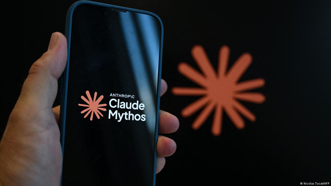 Bir elin tuttuğu akıllı telefon ekranında Anthropic Claude Mythos logosu, arka planda flu olarak aynı logo