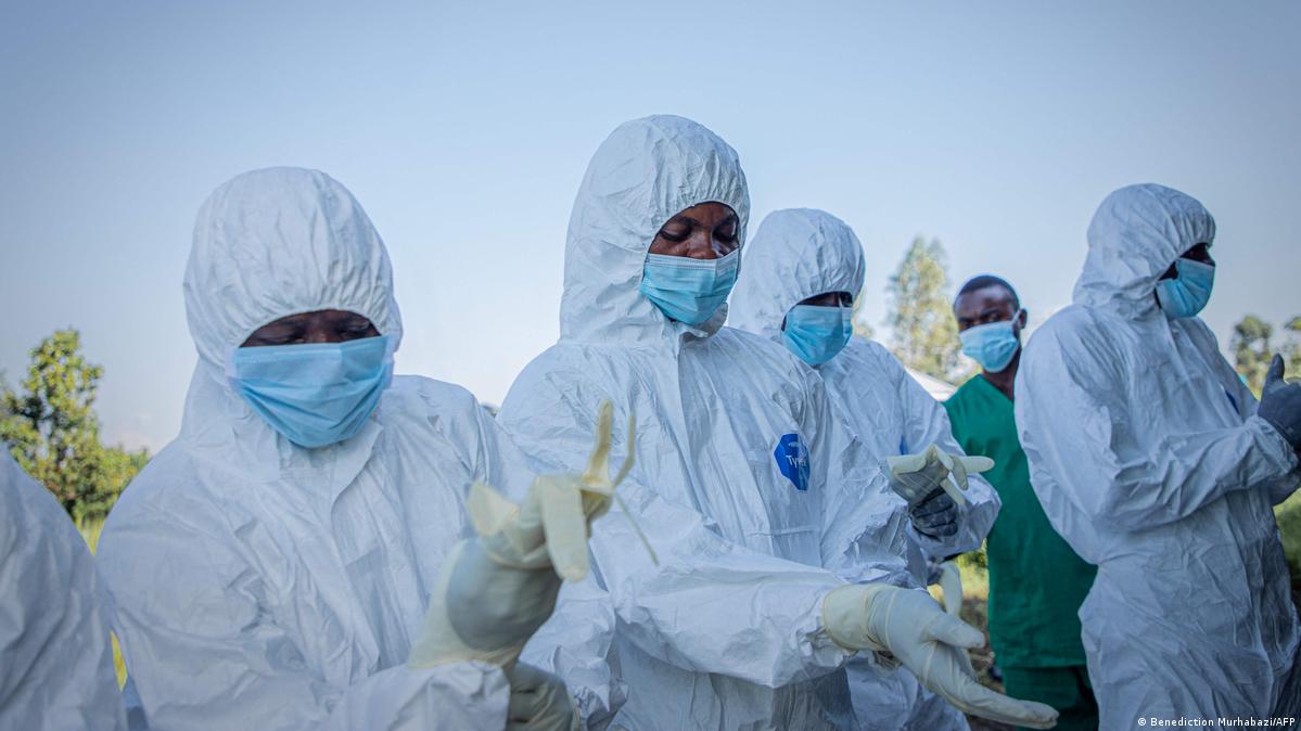 olunteers put on their personal protective equipment before recovering the body of a 3-year-old child, presumed to have died of Ebola virus disease, in Bunia on June 11, 2026.