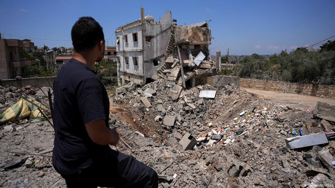 Homem olha prédio no Líbano destruído pelas forças israelenses