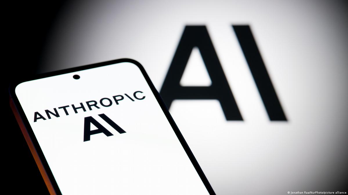 A smartphone pictured with the Anthropic logo, with company branding visible in the background