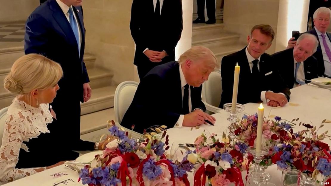Versailles Sarayı'nda Fransa Cumhurbaşkanı Emmanuel Macron'un yanında oturan ABD Başkanı Donald Trump, İslamabad Mutabakat Zaptı'nı imzalarken.