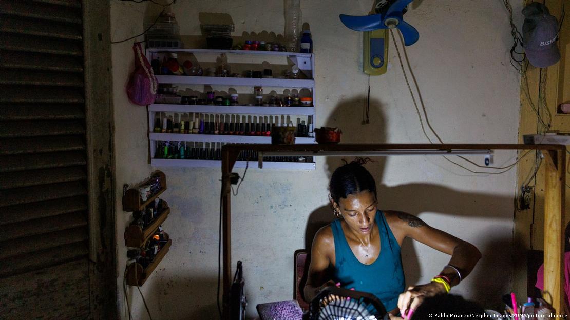 Mulher trabalha em salão de beleza em Havana usando luz gerada por bateria