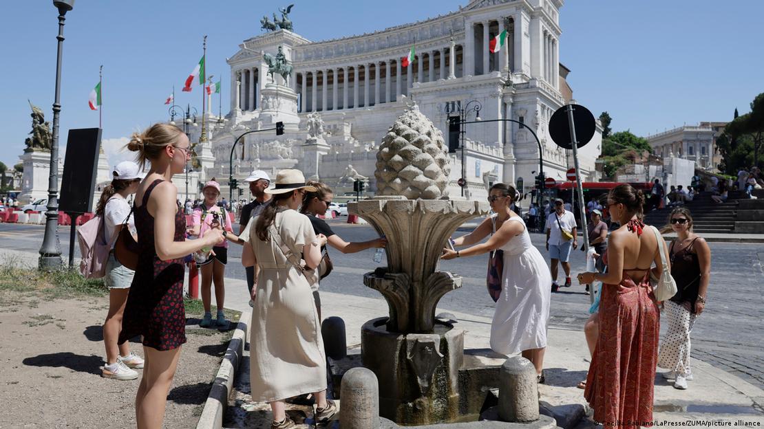 A crowd gathers to drink water at a Roman fountain A crowd gathers to drink water at a Roman fountain