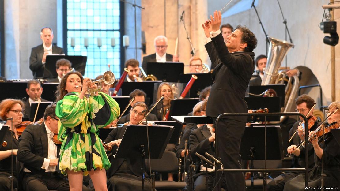 Lucienne Renaudin Vary toca la trompeta, acompañada de una orquesta. 