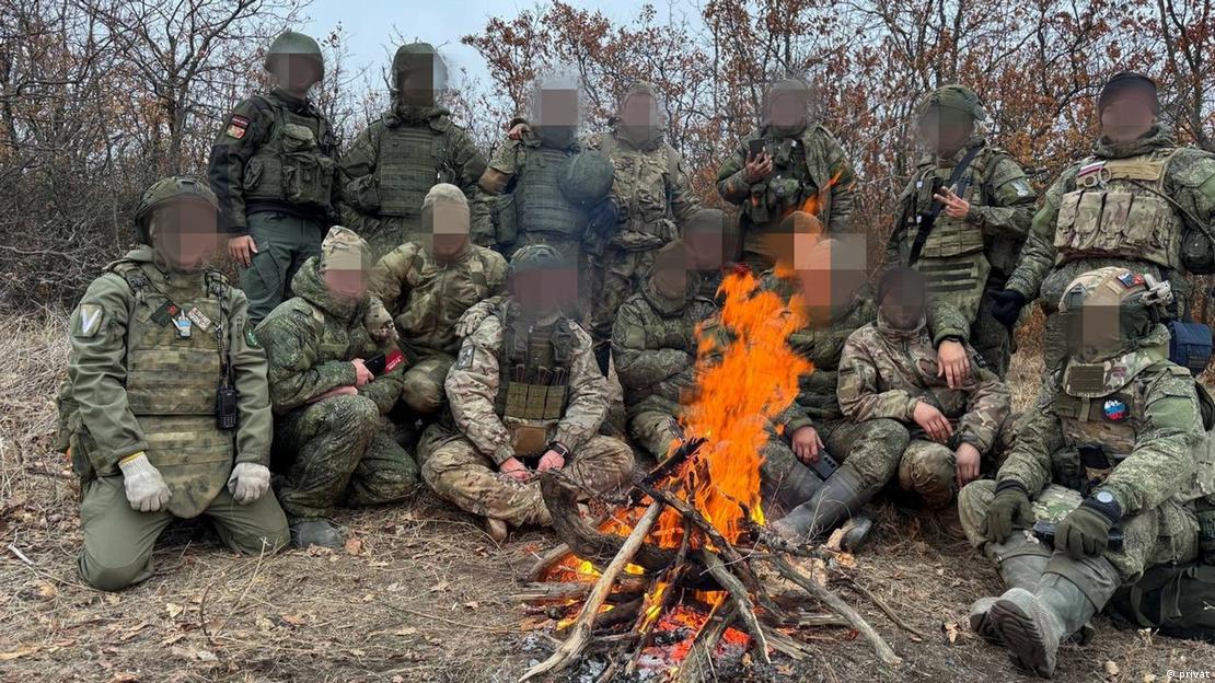Gruppenbild am Lagerfeuer mit verpixelten Gesichtern von Nikitas Swesdows Einheit beim Einsatz auf besetztem ukrainischen Territorium Gruppenbild am Lagerfeuer mit verpixelten Gesichtern von Nikitas Swesdows Einheit beim Einsatz auf besetztem ukrainischen Territorium