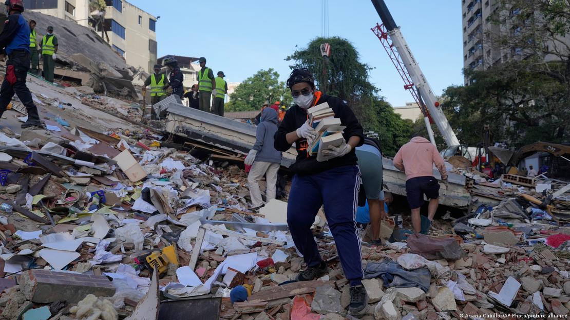 Depremde yıkılan evlerinden eşyalarını kurtarmaya çalışanlar. 
