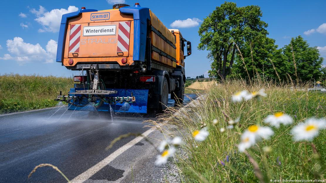 Caminhão esguicha água no asfato de uma rodovia