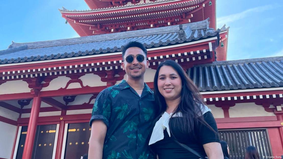 Una pareja posa para una foto frente a una edificación típicamente japonesa