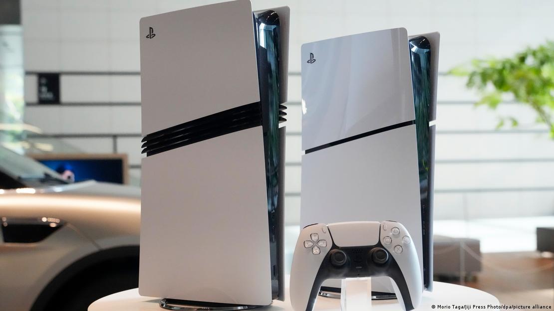 Bir alanda yan yana duran iki PlayStation 5 konsolu ve önlerinde bir DualSense oyun kumandası görülüyor.
