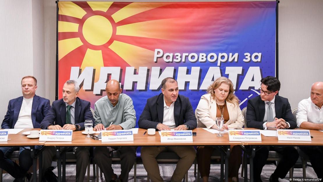 Членови на СДСМ седат на маса. Зад нив стои плакат на кој пишува „Разговори за иднината“  а во горниот лев агол е отсликано македонското знаме