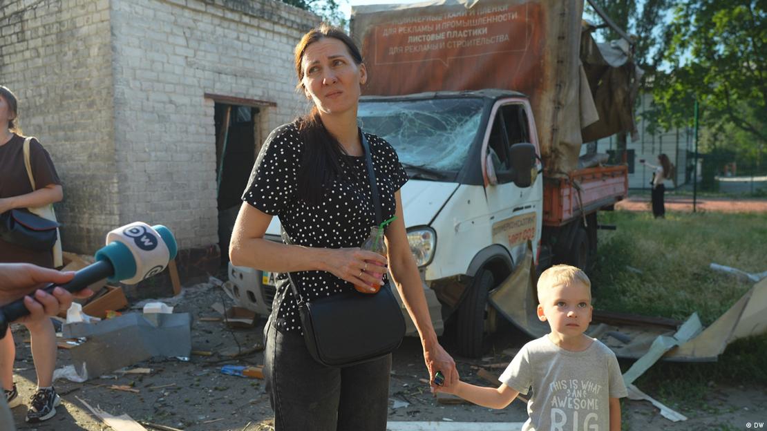 Inna aus Kyjiw hält ihren Sohn an der Hand und spricht in ein Mikrofon des DW-Reporters Inna aus Kyjiw hält ihren Sohn an der Hand und spricht in ein Mikrofon des DW-Reporters