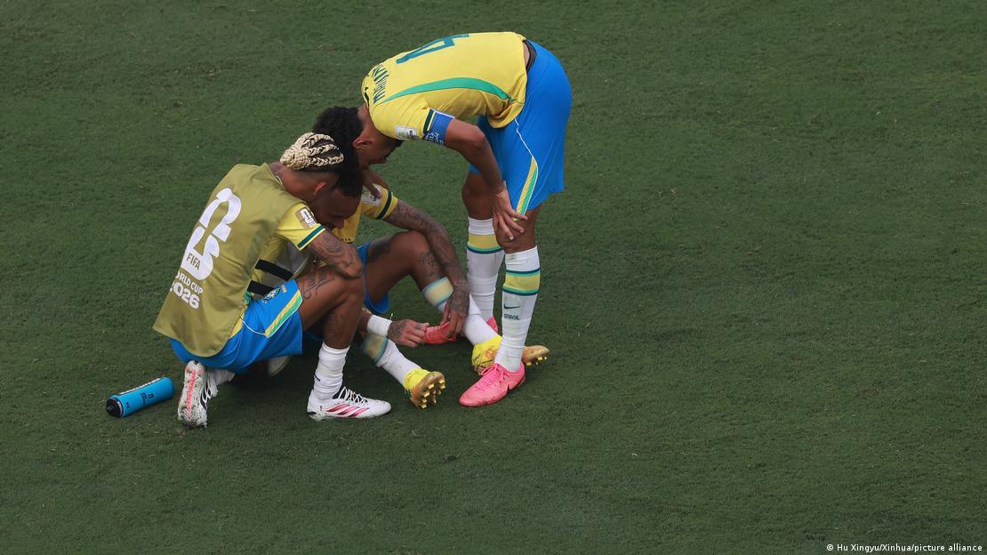 Dois jogadores da seleção brasileira consolam Neymar, que esta sentado no gramado Dois jogadores da seleção brasileira consolam Neymar, que esta sentado no gramado