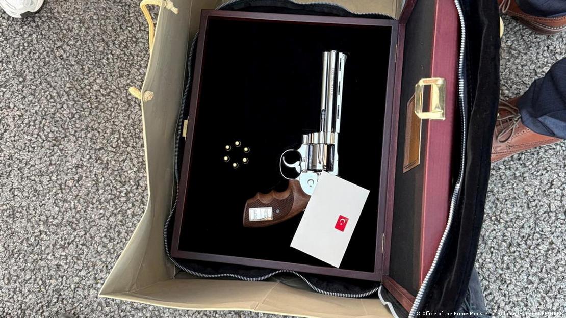 Belçika heyeti, kendi verdiği bilgiye göre, NATO Zirvesi'nde verilen hediyeleri açmadan doğrudan devlet uçağına yükletti ve hediyenin bir revolver ve mermilerden oluştuğu Brüksel Havalimanı'nda anlaşıldı. Hediye paketinin bulunduğu çanta içindeki fotoğrafı