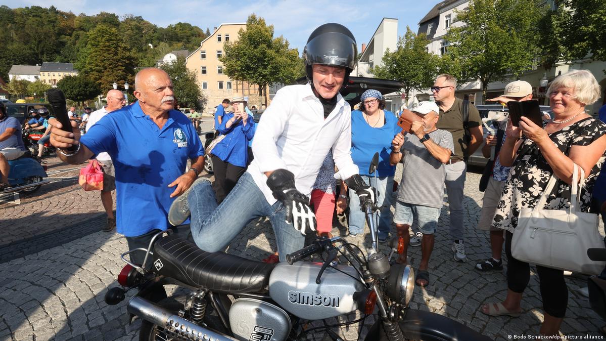 Björn Höcke, surrounded by supporters, mounting a Simson bike on August 30,2024