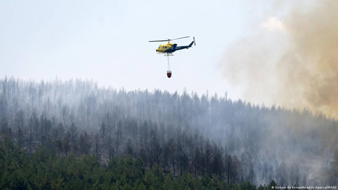 Helicóptero leva água para tentar apagar incêndio florestal